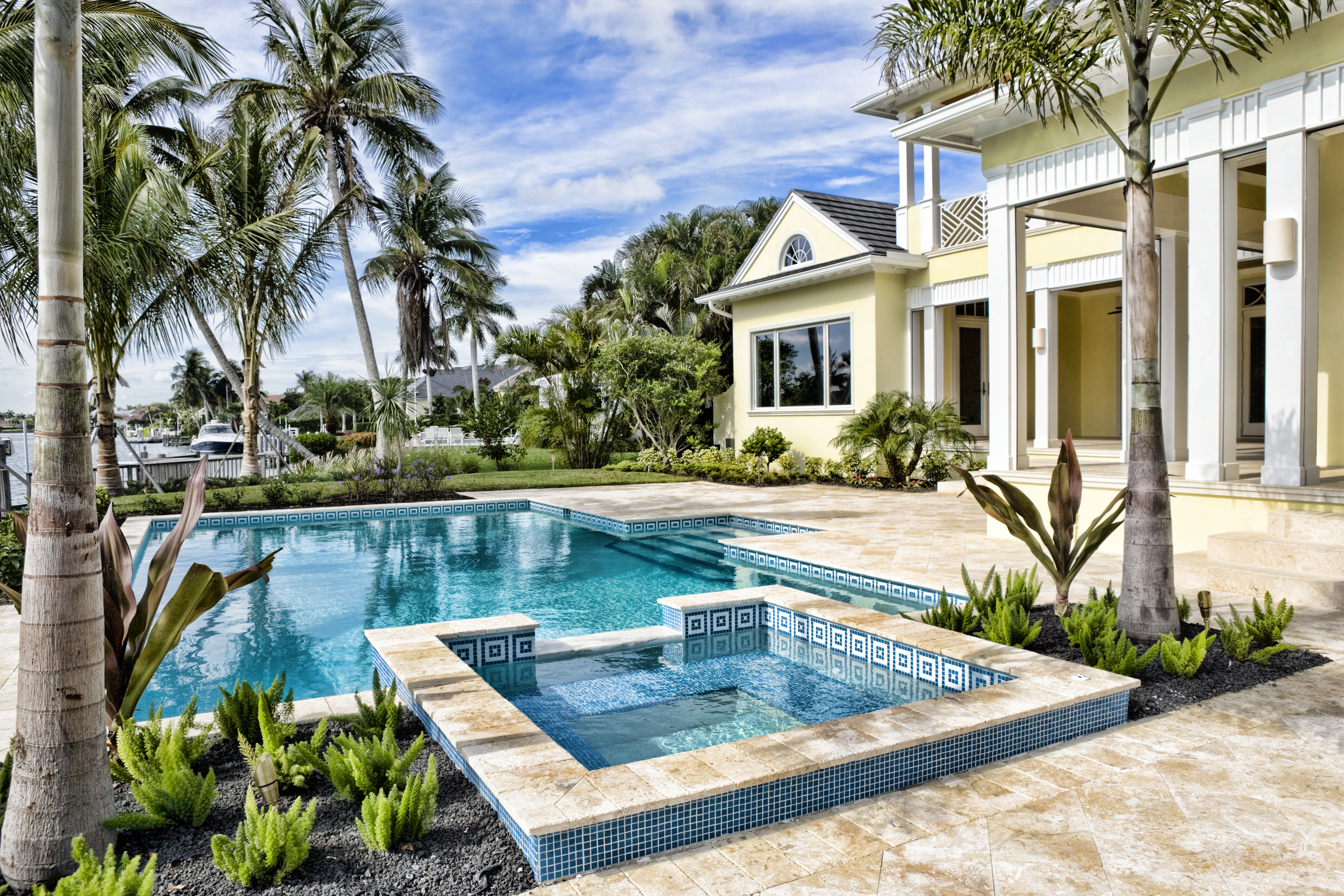 Luxury waterfront homes with a swimming pool and palm trees